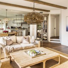 a living room filled with furniture and a chandelier hanging over the top of it