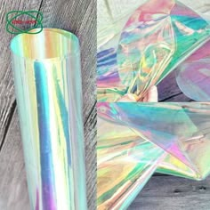 an iridescent sticker sitting on top of a wooden table next to a glass vase