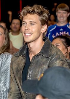 a young man sitting in front of a group of people