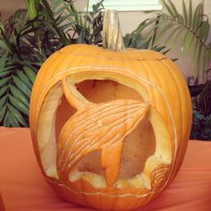 a carved pumpkin with an image of a dolphin on it's face and mouth