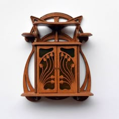 a wooden clock with an intricate design on it's face is shown against a white wall