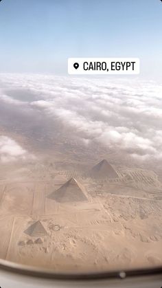 an aerial view of the pyramids and clouds