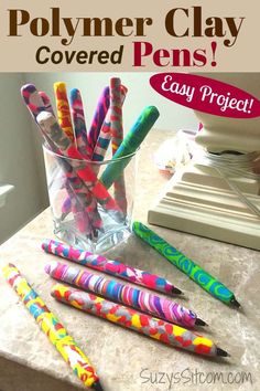 some colorful pens are in a clear vase on a counter with the words polymer clay covered pens