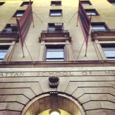 an entrance to the metropolitan school of music in front of a tall building with many windows