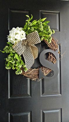 a wreath that has the letter s on it and some flowers in front of it