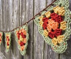 a crocheted banner hanging from a wooden fence