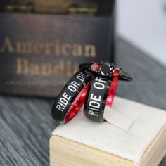 two red and black rings sitting on top of a book