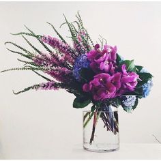 a vase filled with purple flowers on top of a table