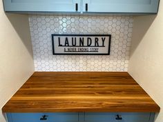 a laundry room with blue cabinets and white tile backsplash, wood counter top