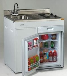 an open refrigerator with the door wide open and food in it next to a sink