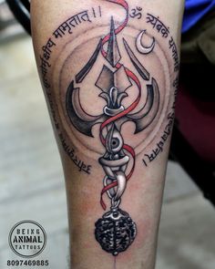 a tattoo on the leg of a man with an anchor and hook in it's center