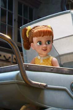 an animated doll with red hair sitting in the back of a blue car and looking at something