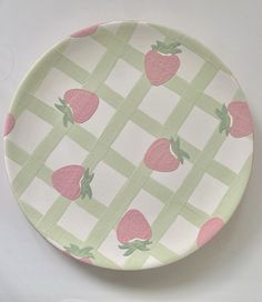 a green and pink plate with strawberries on it