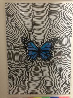 a blue butterfly sitting on top of a black and white swirly background with colored markers