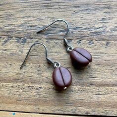 pair of brown earrings sitting on top of a wooden table