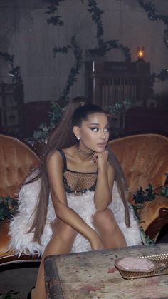 a woman sitting on top of a couch next to a table