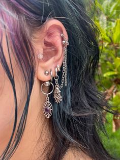 a close up of a person wearing some kind of earring with chains attached to it