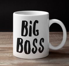 a white coffee mug with the words big boss on it sitting on a wooden table