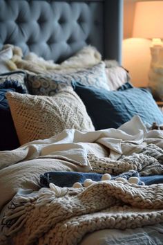 an unmade bed with blankets and pillows on it