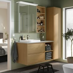 a bathroom with green walls and wooden cabinets