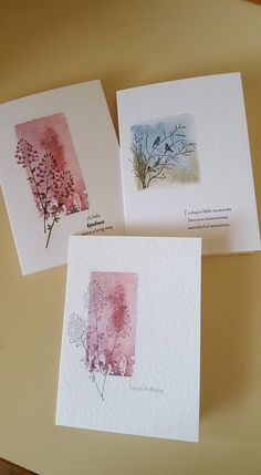 three cards with watercolor designs on them