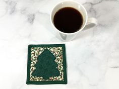 a cup of coffee sitting on top of a table next to a coaster