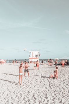 people are playing volleyball on the beach in front of an ice cream truck and lifeguard tower