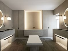 a large bathroom with two sinks and mirrors on the wall, along with three stools