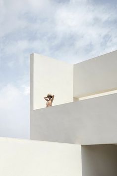 a man standing on top of a white building