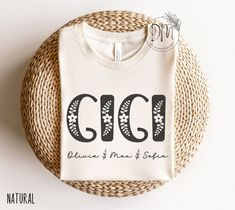 a white t - shirt with the word ggi written in black ink on it