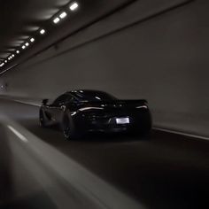 a black sports car driving through a tunnel