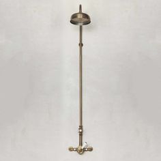 an antique brass wall light on a white wall in a room with no one around it