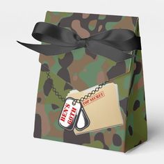 an army camouflage gift bag with tags and a black ribbon tied around the tag on it