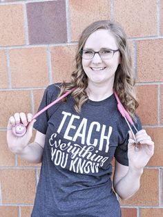 a woman holding two pink toothbrushes in front of her face and wearing a t - shirt that says teach everything you know