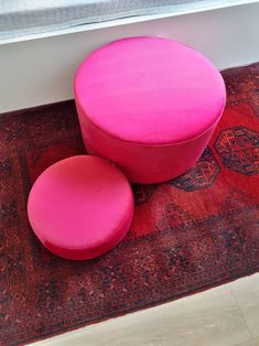 two pink stools sitting on top of a rug