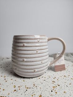 a white coffee cup sitting on top of a table