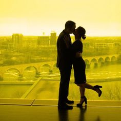 a man and woman standing next to each other in front of a cityscape