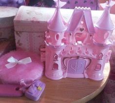 there is a pink princess castle on the table next to it's box and accessories