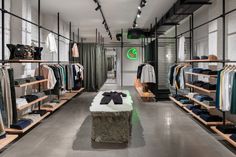 the inside of a clothing store with clothes on racks