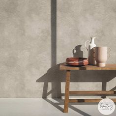 a wooden table with two vases on it and a plate next to the table