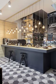 the interior of a restaurant with checkered flooring and lights hanging from the ceiling