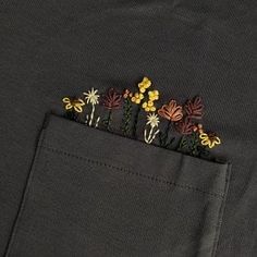 a close up of a pocket with some flowers in the pocket and one flower sticking out of it