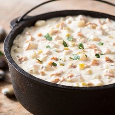 a black pot filled with food on top of a wooden table