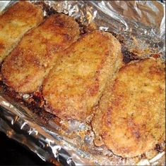 four fried meat patties sitting on top of tin foil