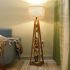 a living room with a blue couch and a wooden floor lamp