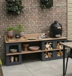 an outdoor bbq grill sitting on top of a patio next to a table and chairs