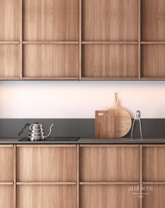 a kitchen with wooden cabinets and black counter tops, including a tea kettle on the stove