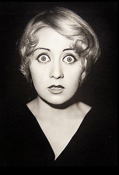 an old black and white photo of a woman making a face with her eyes wide open