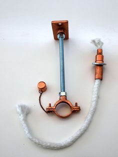 a pipe and fittings attached to a wall mounted hook up on a white surface