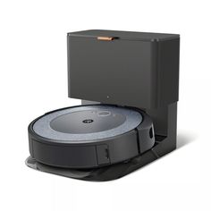 the robotic vacuum is sitting on top of it's stand, with its lid open